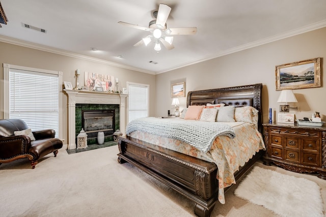 bedroom with carpet floors, ceiling fan, a tile fireplace, and multiple windows