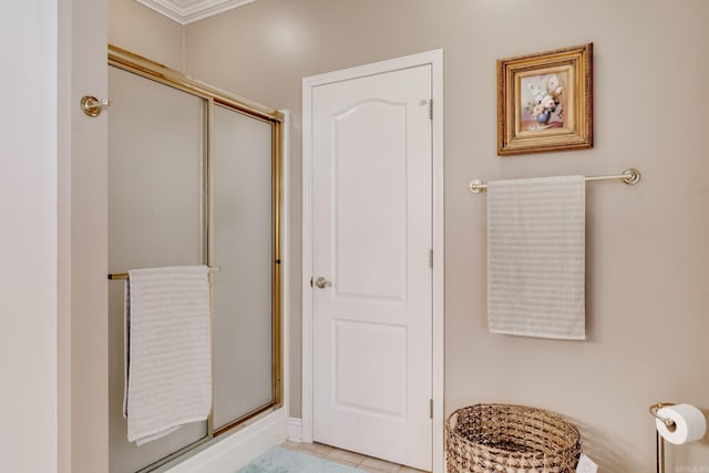 bathroom featuring a shower with door, tile floors, and crown molding