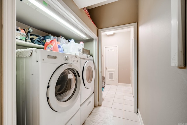 washroom featuring light tile floors and washer and dryer