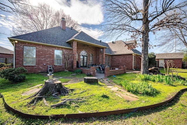 rear view of house featuring a patio area, a yard, and an outdoor structure