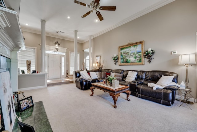 living room featuring carpet, crown molding, ceiling fan with notable chandelier, and ornate columns