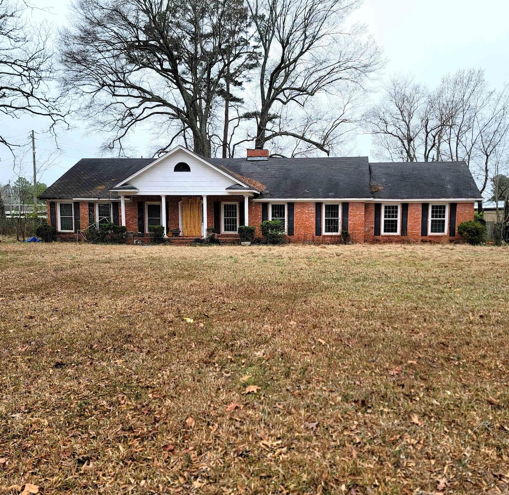 ranch-style house featuring a front lawn and a porch