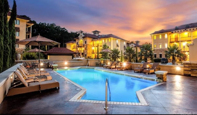 pool at dusk featuring a patio