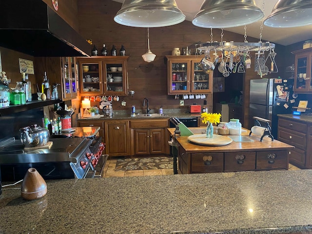 bar featuring black appliances, light tile flooring, sink, dark stone countertops, and wooden walls