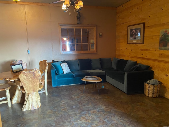 living room featuring wood walls, dark tile floors, and a chandelier