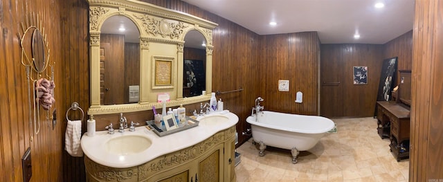 bathroom with dual vanity, tile floors, wood walls, and a washtub