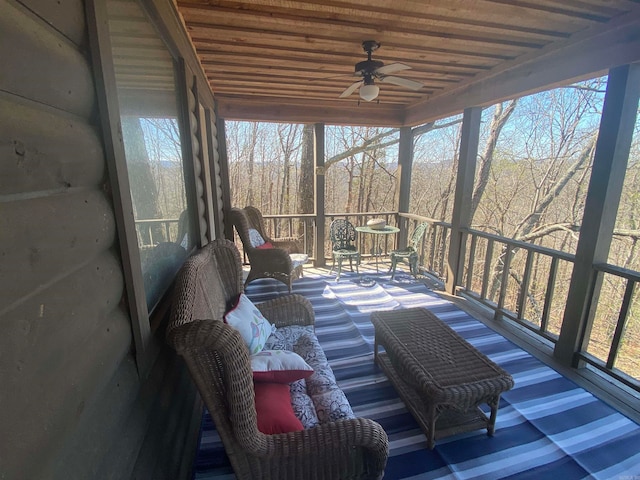 sunroom with ceiling fan, wood ceiling, and a healthy amount of sunlight