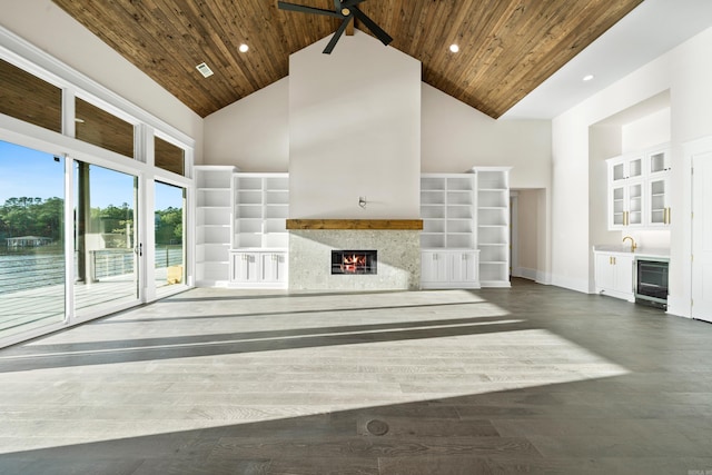 unfurnished living room with high vaulted ceiling, a high end fireplace, beverage cooler, and wooden ceiling