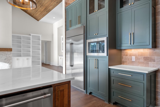 kitchen featuring tasteful backsplash, dark wood-type flooring, glass insert cabinets, built in appliances, and wooden ceiling