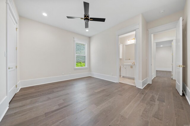 unfurnished bedroom with ceiling fan, recessed lighting, wood finished floors, baseboards, and ensuite bath