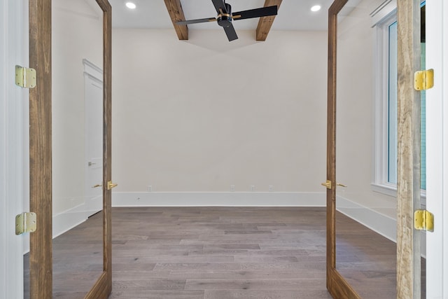 unfurnished room with baseboards, ceiling fan, beamed ceiling, wood finished floors, and french doors