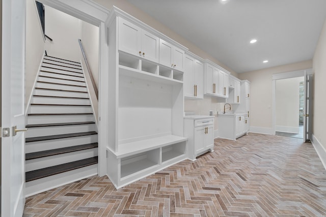 mudroom featuring baseboards, a sink, and recessed lighting