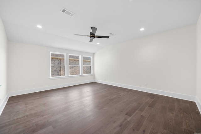 spare room with lofted ceiling, recessed lighting, visible vents, baseboards, and dark wood finished floors