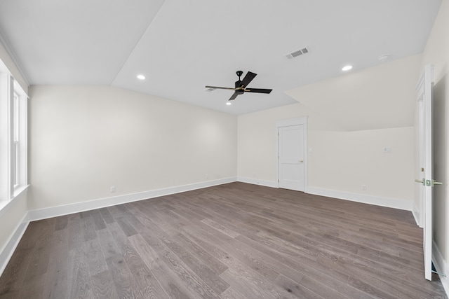 additional living space featuring lofted ceiling, baseboards, visible vents, and dark wood finished floors