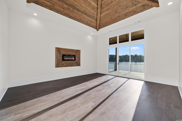 unfurnished living room featuring a glass covered fireplace, recessed lighting, baseboards, and wood finished floors