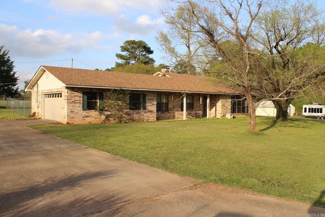 ranch-style house featuring a front yard and a garage