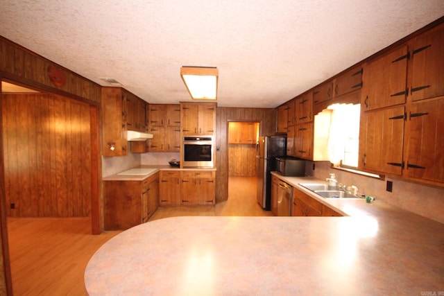 kitchen featuring light hardwood / wood-style floors, stainless steel appliances, a textured ceiling, and sink