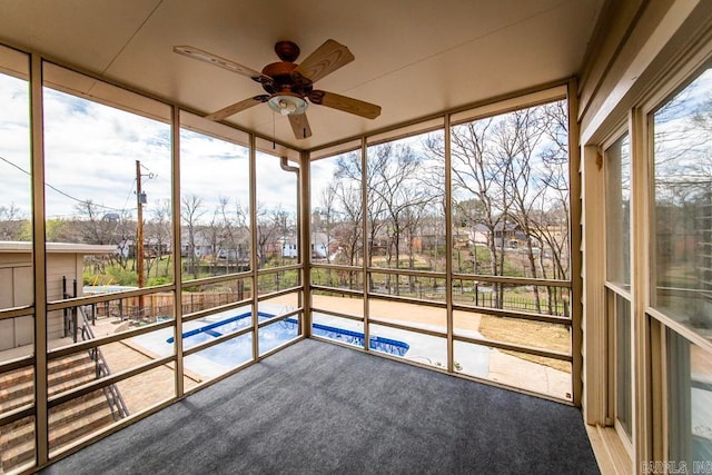 unfurnished sunroom with ceiling fan