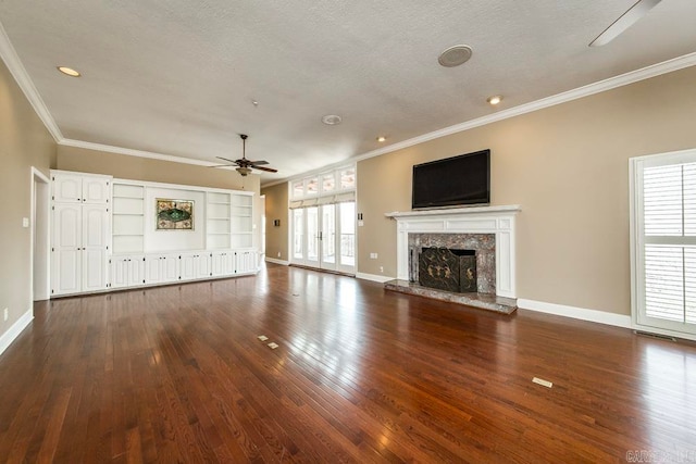 unfurnished living room with a healthy amount of sunlight, ceiling fan, dark wood-type flooring, and a fireplace