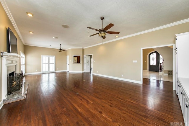 unfurnished living room featuring plenty of natural light, ceiling fan, and dark hardwood / wood-style flooring