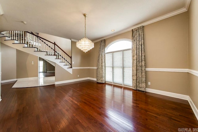 empty room featuring a notable chandelier, ornamental molding, and dark hardwood / wood-style floors