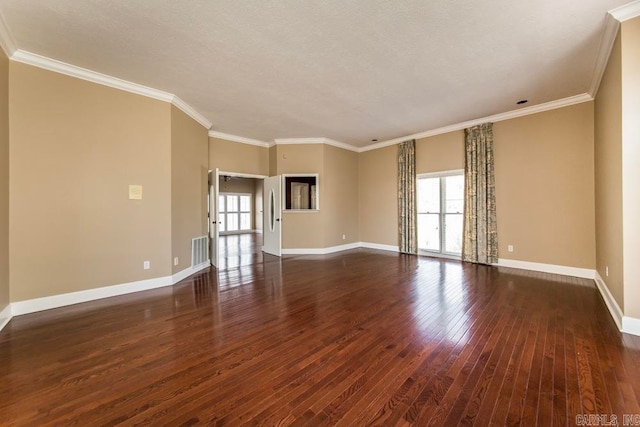 spare room featuring dark hardwood / wood-style flooring, ornamental molding, and a healthy amount of sunlight