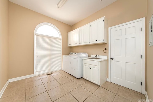 laundry area with independent washer and dryer, sink, cabinets, and light tile floors