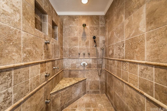 bathroom with ornamental molding and a tile shower