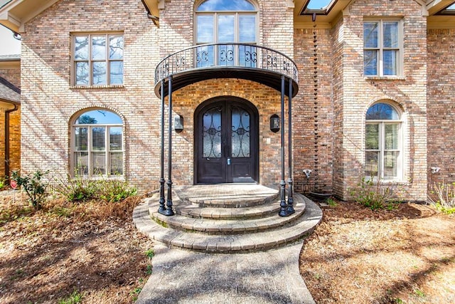 doorway to property with a balcony and french doors