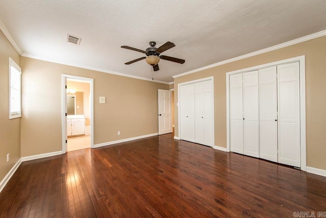 unfurnished bedroom featuring ensuite bath, ornamental molding, dark hardwood / wood-style flooring, and ceiling fan