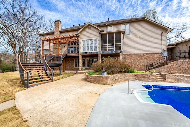 back of property with a patio area, a pergola, and a swimming pool side deck