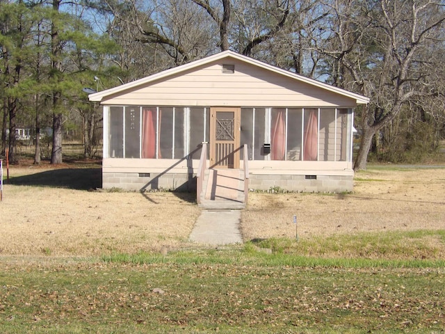 view of front of house featuring a front yard and a sunroom