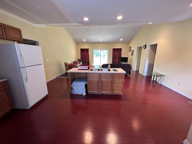 kitchen with dark hardwood / wood-style flooring, lofted ceiling, a kitchen island, and white fridge