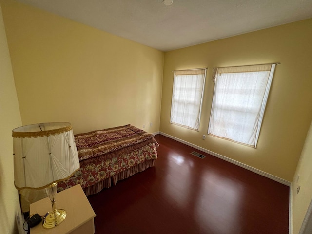 bedroom with dark hardwood / wood-style flooring