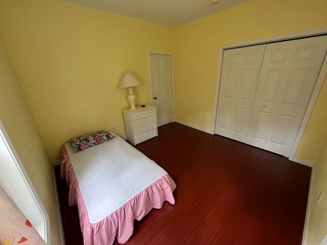 bedroom with dark wood-type flooring and a closet