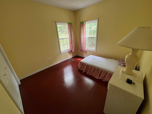 bedroom with dark wood-type flooring