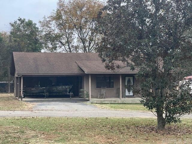 ranch-style house with a front lawn, covered porch, and a garage