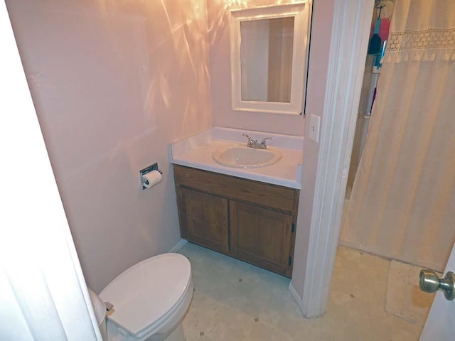 bathroom featuring toilet, large vanity, and tile floors