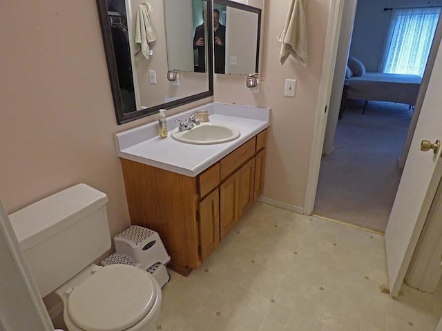 bathroom featuring vanity, tile flooring, and toilet