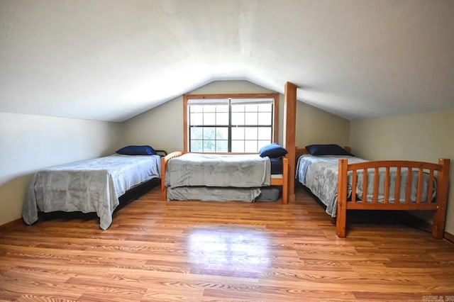 bedroom featuring light wood-type flooring and lofted ceiling