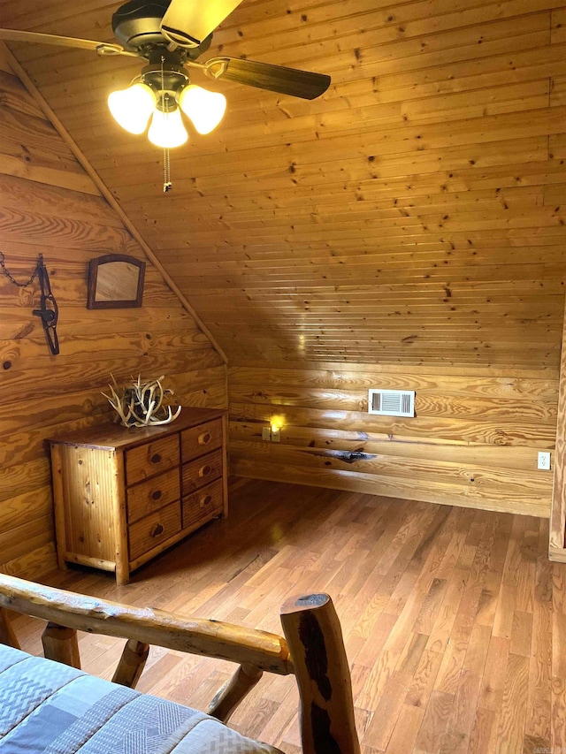 unfurnished bedroom featuring light hardwood / wood-style floors, wooden ceiling, ceiling fan, wooden walls, and lofted ceiling