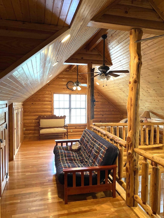 bedroom with vaulted ceiling with skylight, light hardwood / wood-style floors, wooden ceiling, and rustic walls