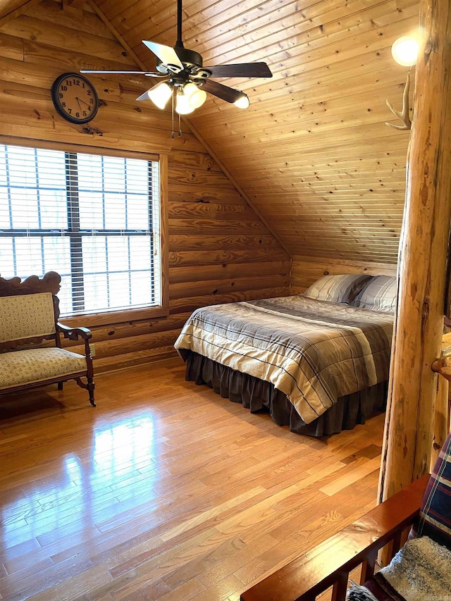 bedroom with light wood-type flooring, lofted ceiling, ceiling fan, rustic walls, and wood ceiling