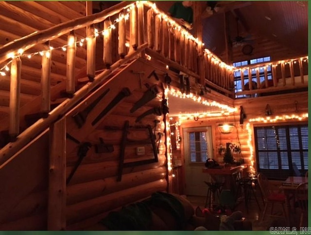 interior space with a towering ceiling and log walls