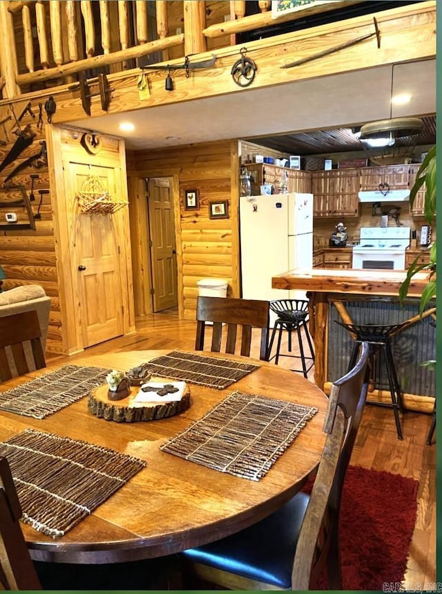 dining space with rustic walls and light hardwood / wood-style flooring