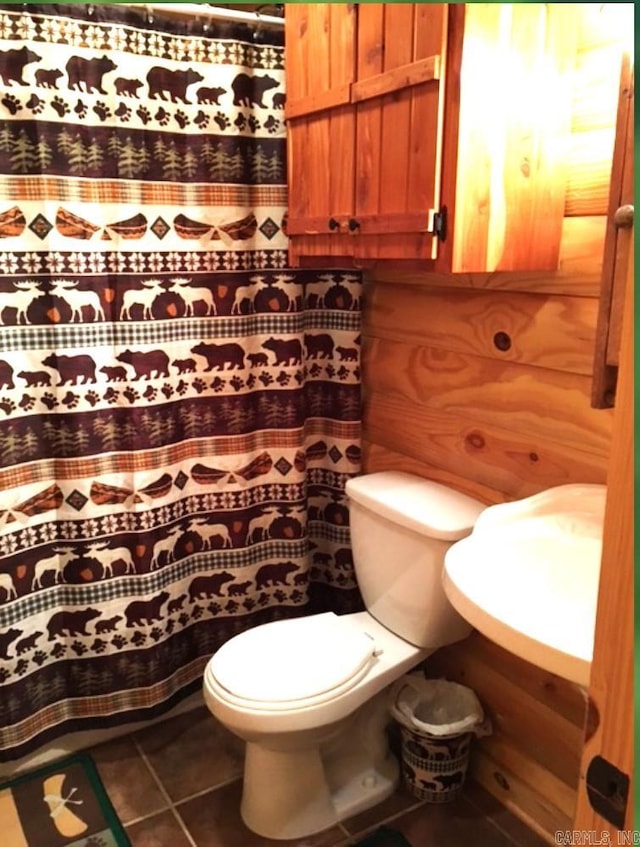 bathroom featuring toilet, tile floors, and sink