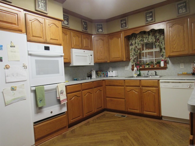 kitchen with tasteful backsplash, white appliances, sink, and dark parquet flooring