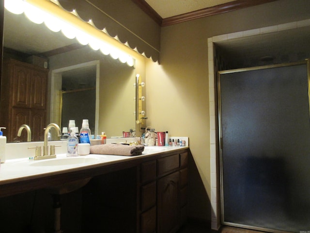 bathroom featuring ornamental molding, an enclosed shower, and vanity