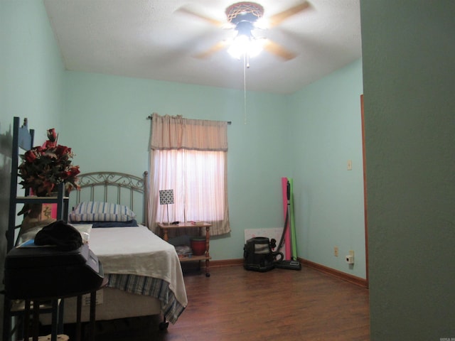 bedroom with dark hardwood / wood-style floors and ceiling fan