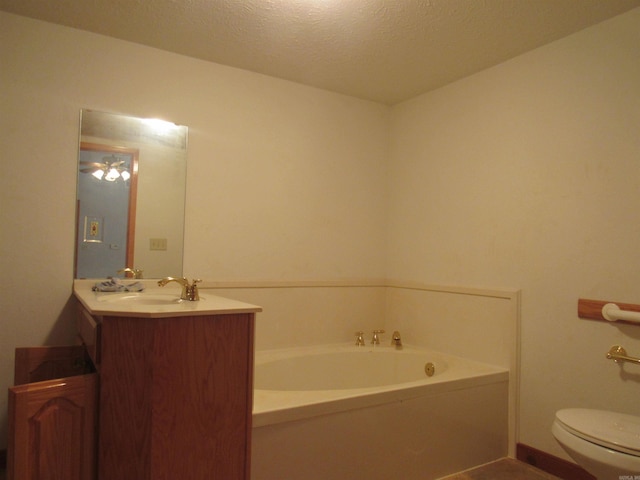 bathroom with toilet, vanity, a bathing tub, and a textured ceiling